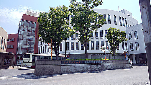 春日部共栄の校門、スクールバスも見えている。